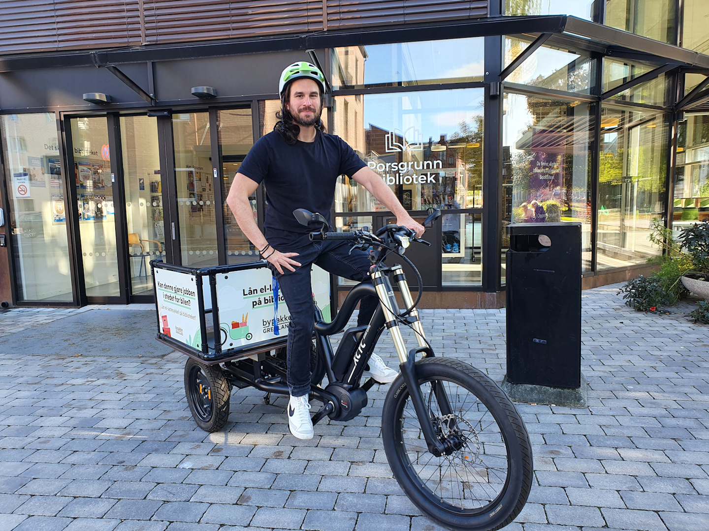 Foto: Marcus Patai, ved biblioteket i Porsgrunn prøvesitter den nye sykkelen (Foto: Bypakke Grenland)