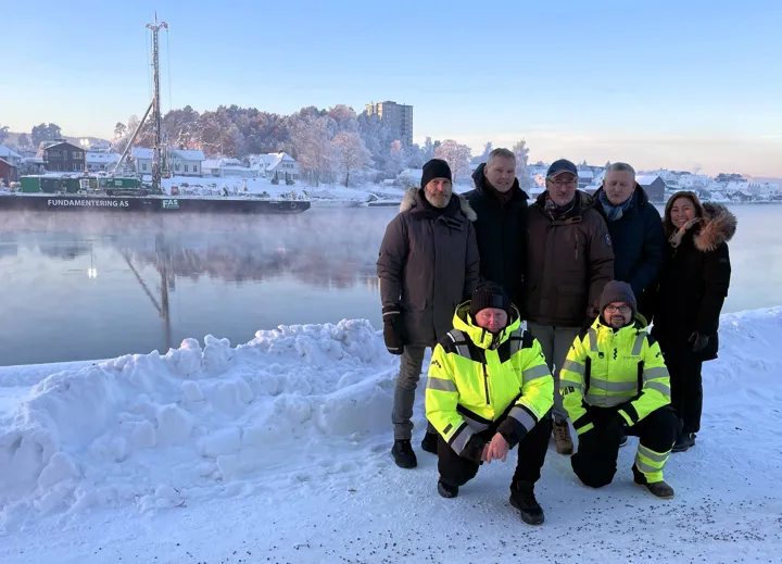 Foran fra venstre i gule jakker: prosjektleder Jan Atle Einerkjær og HMS/KS-leder Steffen Monrad i Consto Anlegg Sør as. Bak fra venstre: prosjektleder ved Bygg- og eiendomsdrift Morten Ødegaard, konstituert rådmann Per Sortedal, medlem av Utvalg for miljø og byutvikling Ole Kåre Wagenius (Ap), bygg- og eiendomssjef Ole Henrik Lia og ordfører Janicke Andreassen i Porsgrunn kommune. Lekteren med pelerigg kan sees i bakgrunnen.