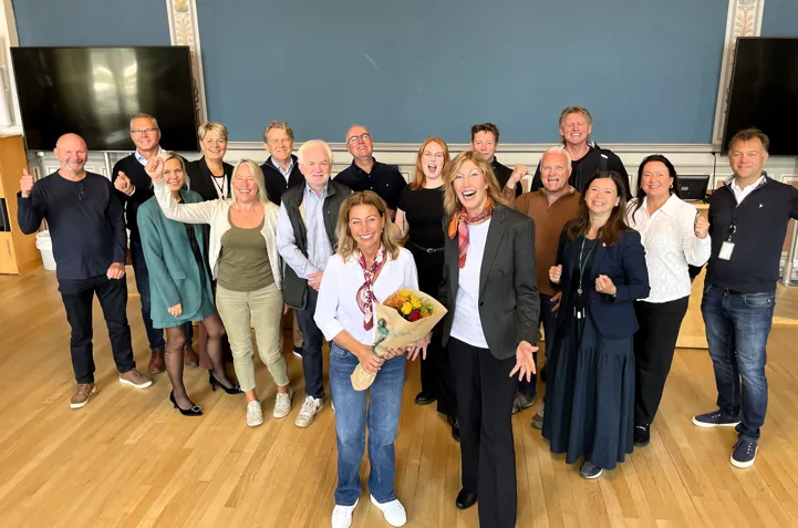 Bilde: NHOs regiondirektør Kristin Saga overrakte blomster og gode nyheter til politikere og administrasjonen etter valgstyremøtet onsdag.